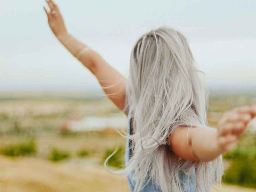 Woman with silver hair, happy, free, enjoying nature.